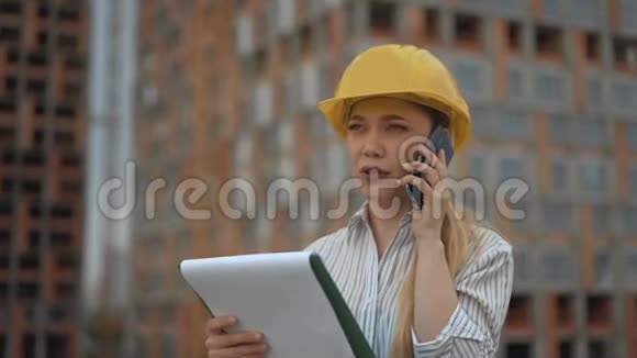 特写镜头女工头在电话里说着手里拿着房子的计划视频的预览图