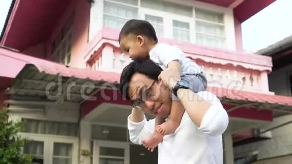亚洲的父亲在房子前为小儿子搭车视频的预览图