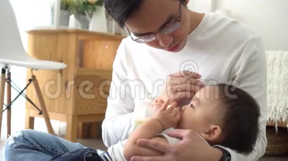 亚洲一家小父亲用奶瓶喂小男孩视频的预览图