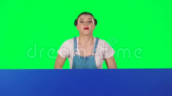 女人从蓝色的空白标语牌后面望出去看着他赞许地点头像是慢动作视频的预览图