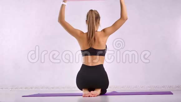 苗条的女士适合教练使用伸展器械为肌肉后面的身体做有氧运动视频的预览图
