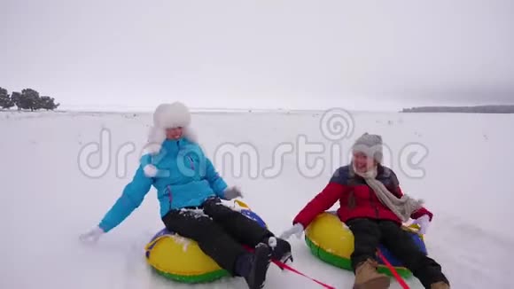 孩子们和妈妈在冬天骑雪橇母女俩在冬季公园玩圣诞假期的概念视频的预览图