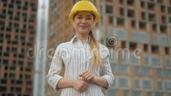 好的自信快乐的女工程师戴着安全帽看着镜头露出一个好的姿势视频的预览图