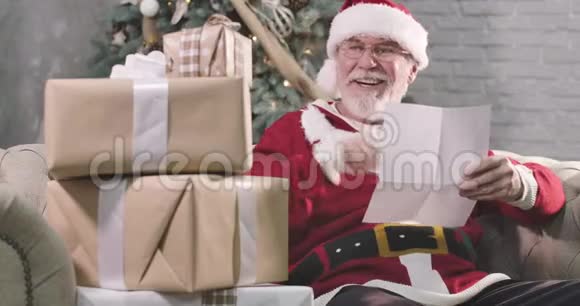 圣诞老人的肖像白胡子读信看礼物盒微笑戴眼镜的老人视频的预览图