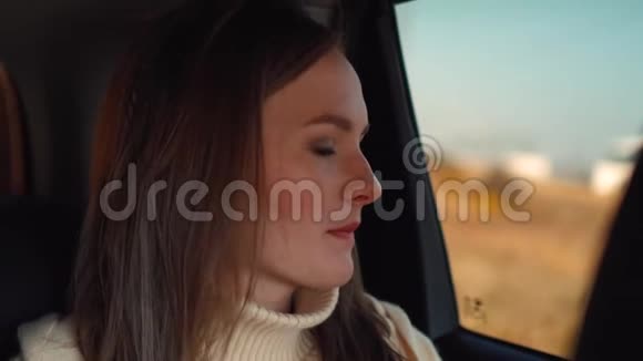 年轻女孩坐在车里看着窗外视频的预览图