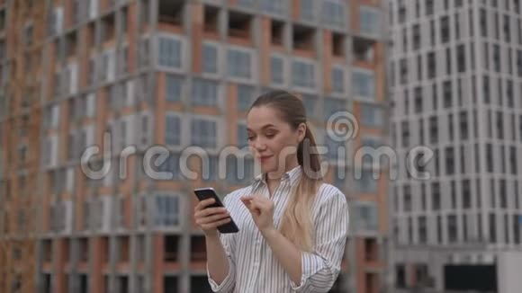 特写女子脸上一个工地背景女人手里拿着一部手机4K视频的预览图