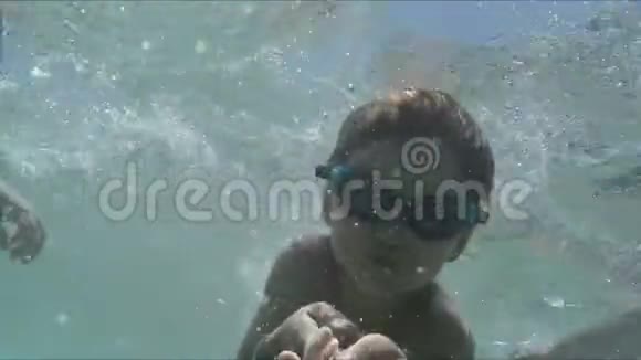 男孩在阳光下在游泳池里游泳视频的预览图
