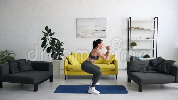 漂亮的年轻女子在房间的地毯上做腹部运动视频的预览图