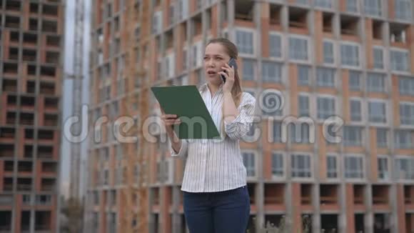 女工程师在电话里拿一个建筑计划和周四比较成功的商业理念工作视频的预览图