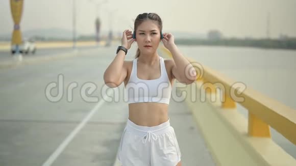 慢动作运动员女子在海滩路跑步亚洲女跑运动员夏季耐力训练视频的预览图
