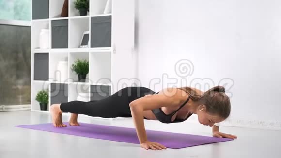 运动服装中的女肌肉运动员在健身房进行地面运动视频的预览图