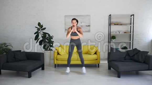漂亮的年轻女子在房间里做腹部运动视频的预览图