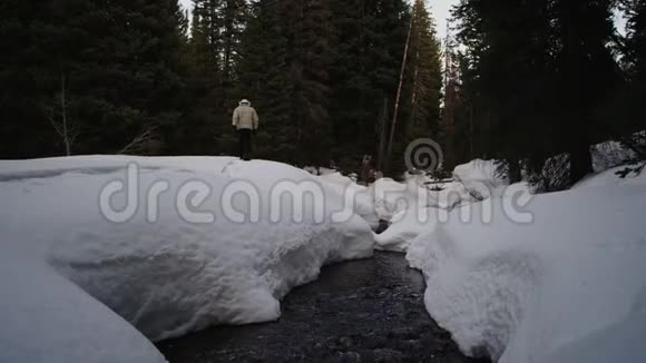 雪鞋在大雪滩的小溪旁视频的预览图