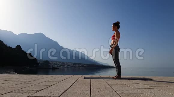 灵活的女孩在风景优美的海景里练习瑜伽视频的预览图