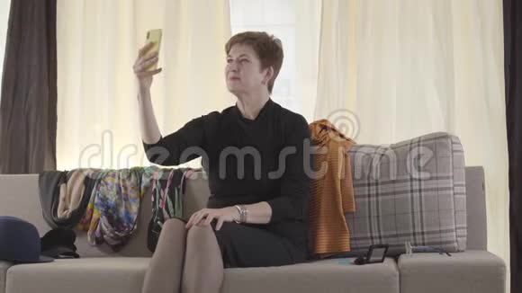 性格开朗的白人高级女性拿着智能手机在自拍相机上聊天成熟女博主录音录像视频的预览图
