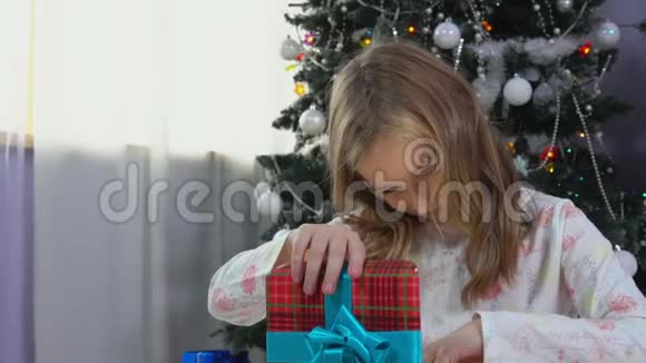 金发女孩在圣诞节早晨打开礼物视频的预览图