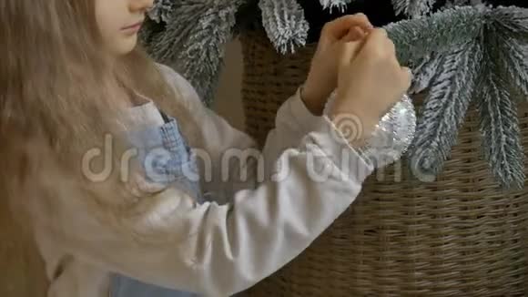 小女孩正在用大银宝装饰圣诞树可爱的金发女孩准备回家过圣诞节视频的预览图