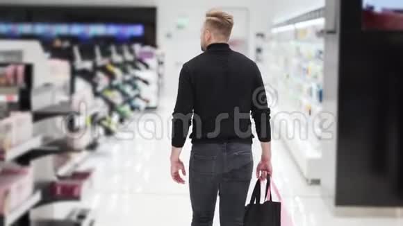 从侧面看一个带着购物袋的人去了化妆品商店Steadam射击视频的预览图