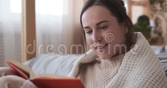 女人一边看书一边包在毯子里视频的预览图