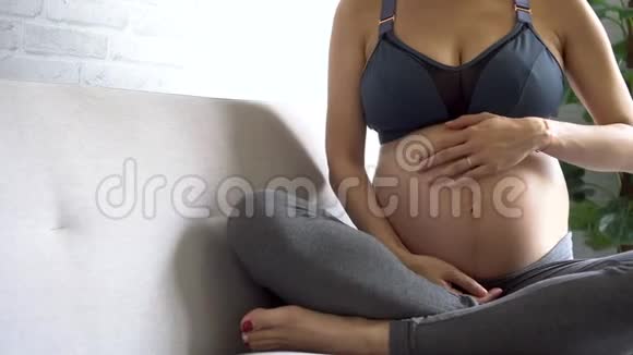 穿着运动服摸肚子的亚洲孕妇视频的预览图
