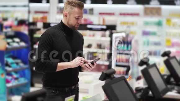 男人在商店里用手机支付购买非接触式支付技术视频的预览图