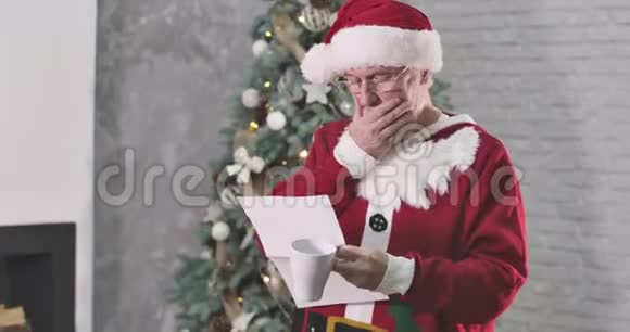 体贴的老白种人穿着圣诞老人服装读信抚摸着白胡子挠着头圣诞老人视频的预览图