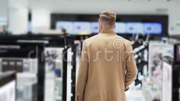 从侧面看穿着棕色外套的年轻人去购物中心Steadam射击视频的预览图