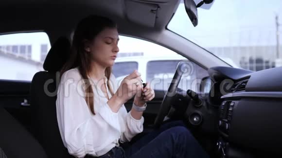 马斯卡拉在车里一个漂亮的女孩化妆车轮后面有危险很早就散了已故的女商人视频的预览图