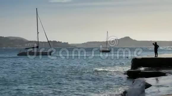 活跃的中年妇女旅行者在平坦的水泥码头在海湾中地形海表锚定游艇对中午的太阳视频的预览图