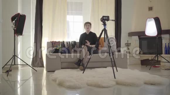 中镜头的成年黑发白种人妇女解释时尚细节的相机老太太穿上五颜六色的衣服视频的预览图