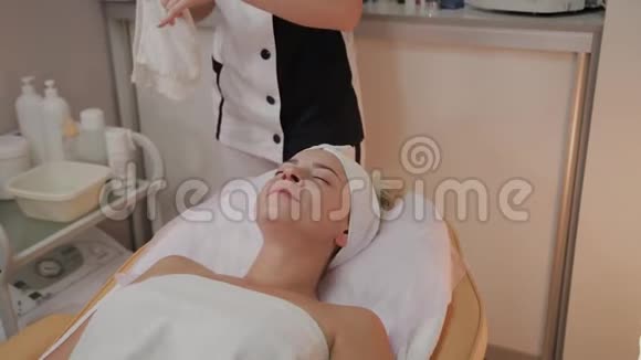 专业美容师从女人脸上取下毛巾擦拭视频的预览图