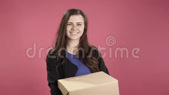 幸福的女人拿着粉红色背景的盒子视频的预览图