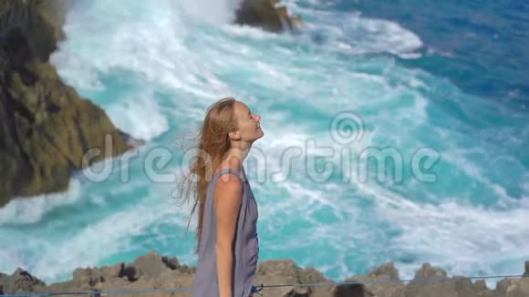 年轻的女游客参观天使的Billabong海滩在NusaPenida岛上巨浪正在袭来视频的预览图