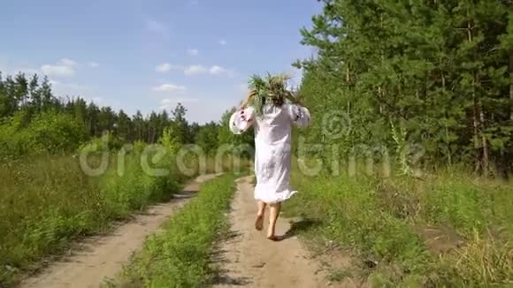 夏天穿着民族服装的快乐赤脚女孩在农村公路上奔跑视频的预览图