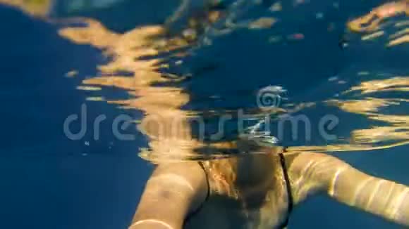 穿着泳衣的年轻女子在帆船附近的海里游泳视频的预览图