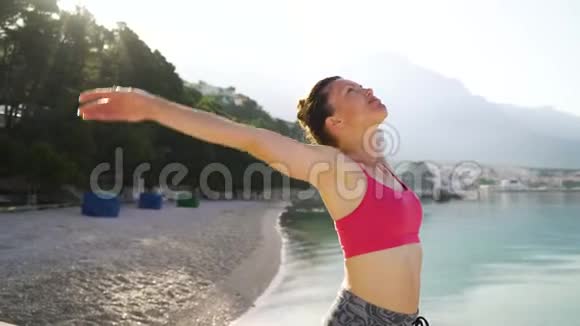 早上在海滨做瑜伽的成年健康女性视频的预览图