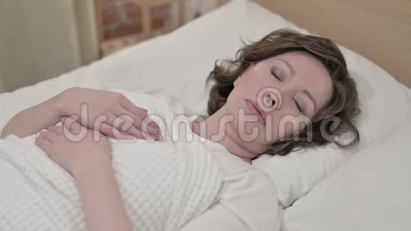 生病的老妇人在床上咳嗽视频的预览图