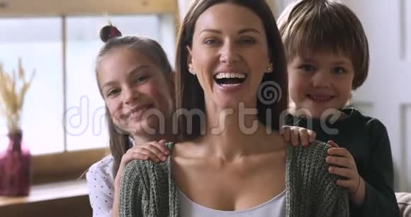 可爱的孩子从背后拥抱妈妈家庭肖像视频的预览图