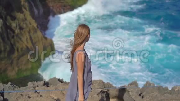 年轻的女游客参观天使的Billabong海滩在NusaPenida岛上巨浪正在袭来视频的预览图