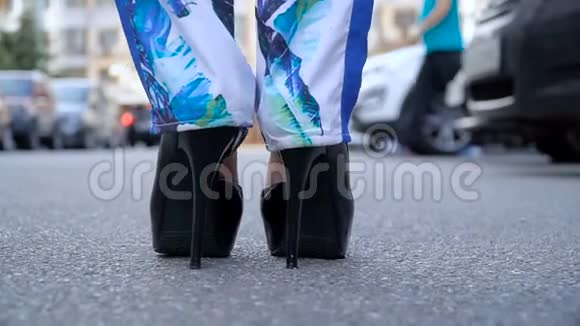 女人的腿穿着高跟鞋走在路上慢动作视频的预览图