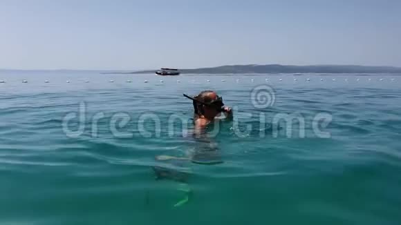 快乐的少女浮潜带着面具和脚蹼靠近海洋浮标视频的预览图