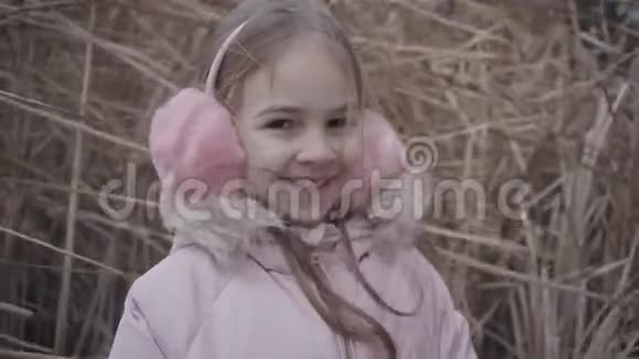 美丽的白种人女孩的肖像棕色的眼睛看着相机微笑穿着粉红色外套的性格开朗的孩子视频的预览图