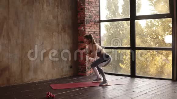 金发健身女运动员做一项复杂的运动来增强肌肉做深蹲和跳木板视频的预览图