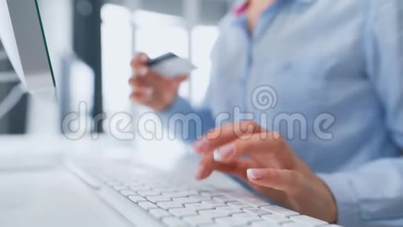妇女在电脑键盘上输入信用卡号码女人在网上购买在线支付服务视频的预览图