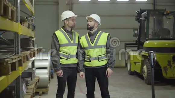 两名白人男性工人站在钢铁厂谈话的肖像工作人员计划他们的工作日雇员视频的预览图