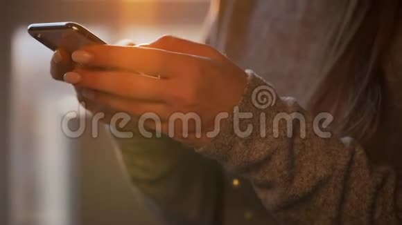 女性用智能手机对抗夕阳视频的预览图