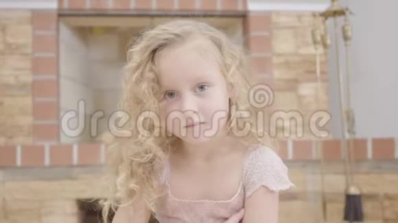 一个可爱的白人金发女孩的肖像卷发看着相机一个漂亮的孩子在视频的预览图