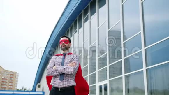 大风天身穿红色斗篷戴面罩的强势商人肖像视频的预览图