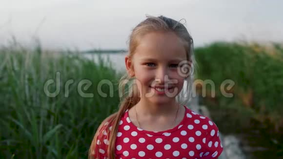 有趣的小女孩微笑着漂亮的脸看着摄像机的孩子视频的预览图