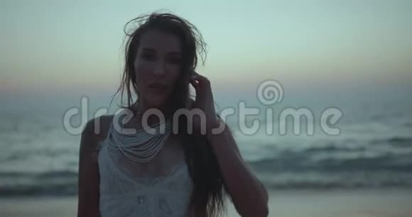 海滩上美丽的黑发女人的浪漫肖像视频的预览图